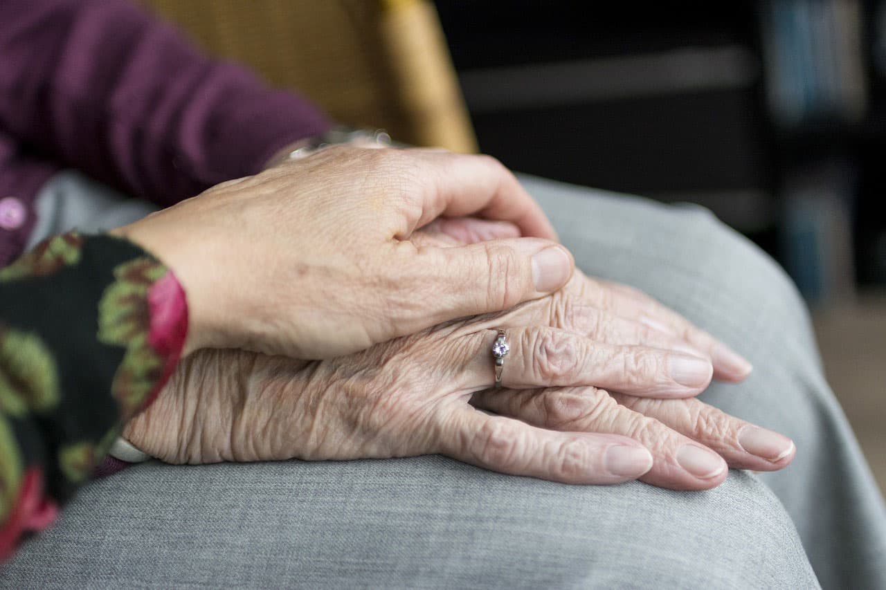 A carer holding an older person's hands